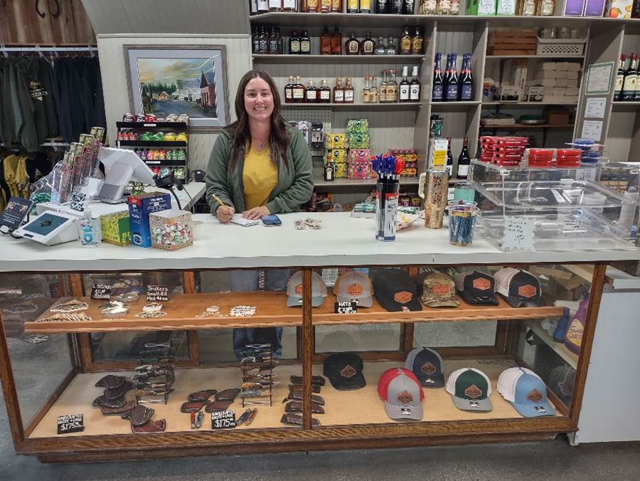 A person standing behind a counter

Description automatically generated